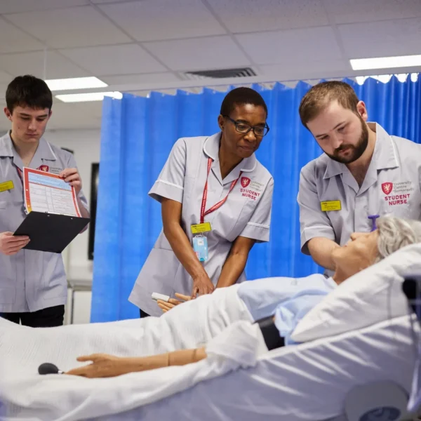 Medical students observing a simulation on a patient.