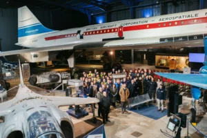 A group of people gathered around in an aviation museum or hangar