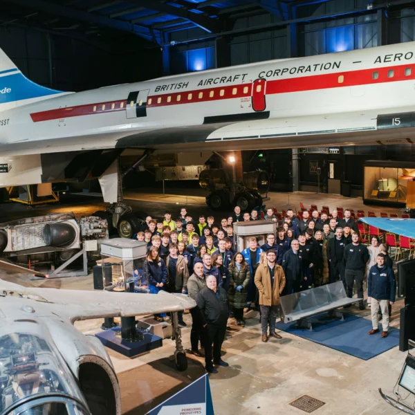 A group of people gathered around in an aviation museum or hangar