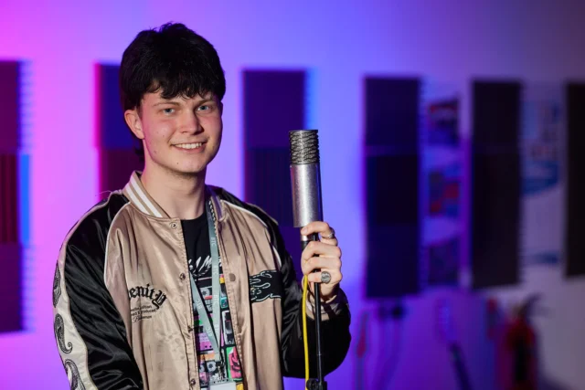 Young man holding a microphone in a recording studio