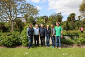 Six people standing together in a garden