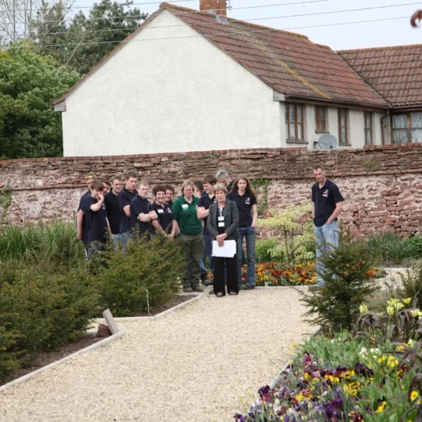 a group of people posing on a garden path