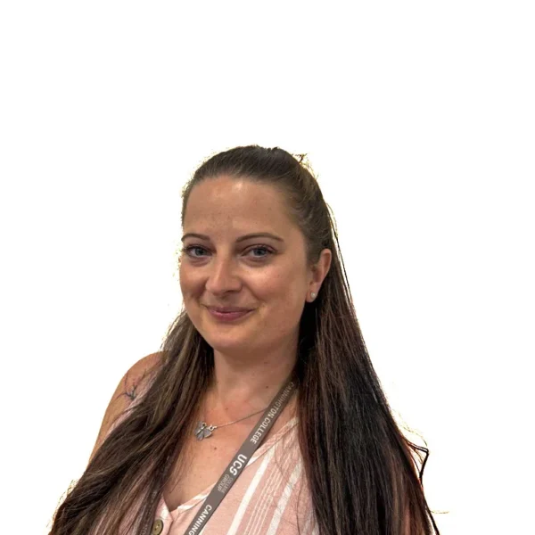 A smiling woman with long dark hair wearing a pink and white striped top and a decorative lanyard.