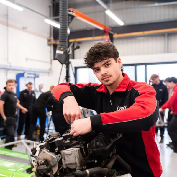 Young mechanic working on a car engine in a garage.