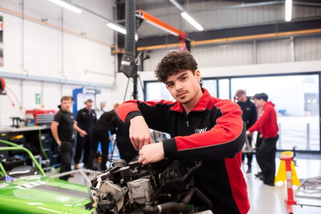 Young mechanic working on a car engine in a garage.