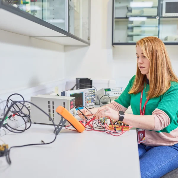 A woman working on an electronic circuit board