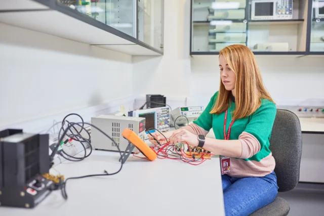 A woman working on an electronic circuit board
