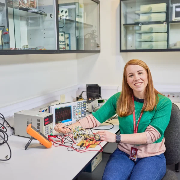 Woman working with electronic equipment in a lab.