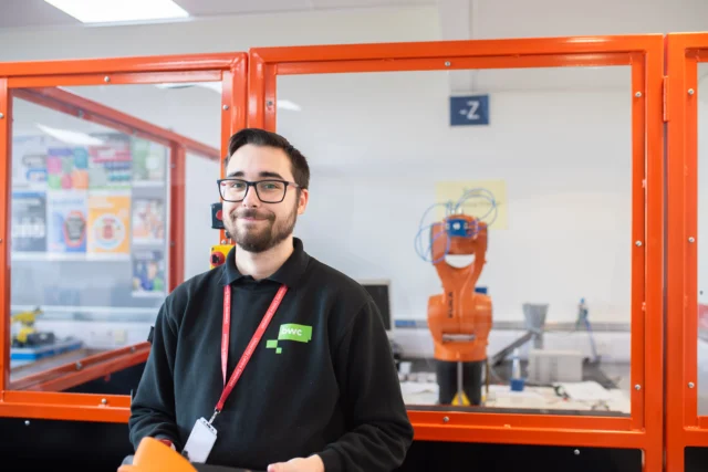 A man standing in front of a robot display.