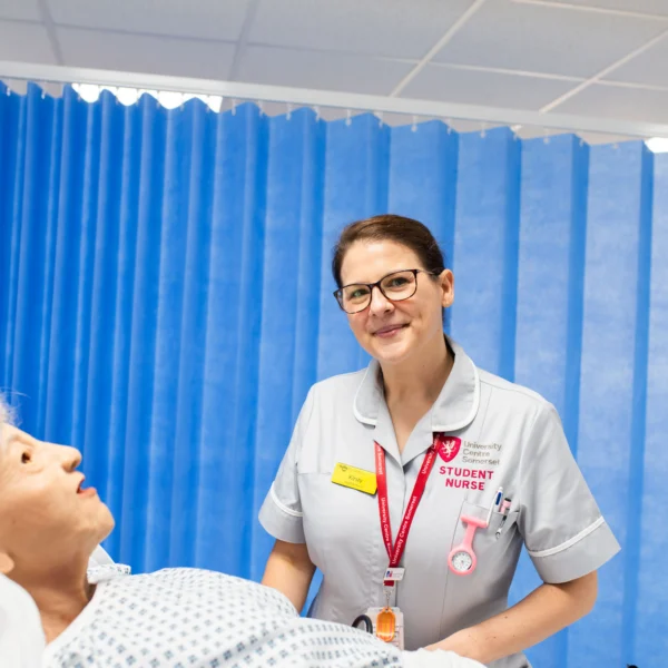 Nurse smiling at a patient lying in a hospital bed