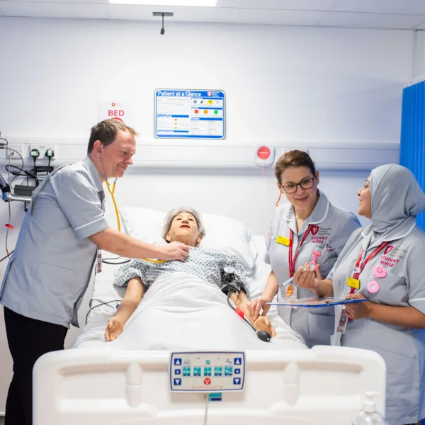Medical team attending to a patient in a hospital bed.