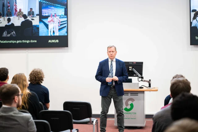 Sir Martin Connell in a blue blazer standing at a podium in front of an audience presenting at the Nuclear Engineering Degree Apprenticeship conference 2026.