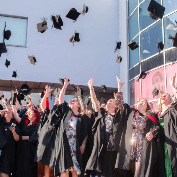 Graduates throwing their caps in the air, celebrating their achievement. Joyful moment of academic success.