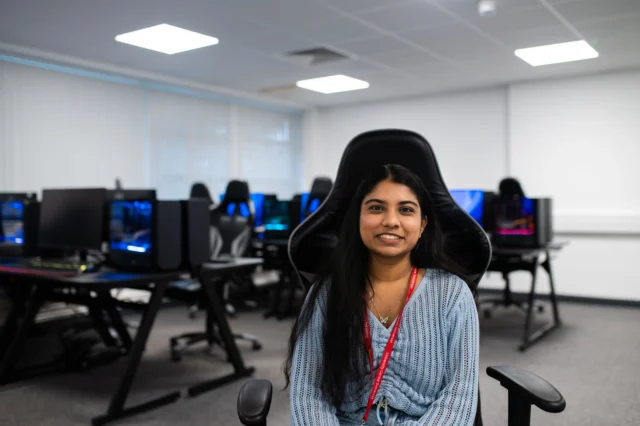Young woman in a computer lab with a blurred background of computers.