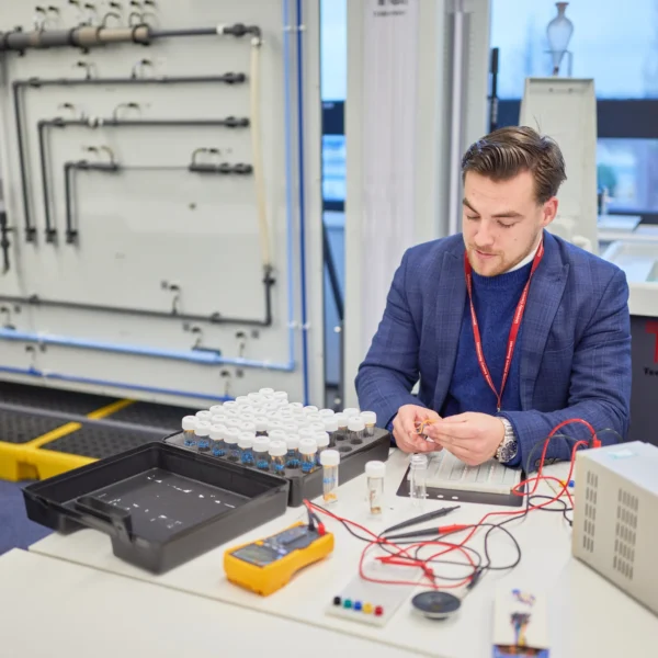 Man working on an electronic device in a laboratory setting.