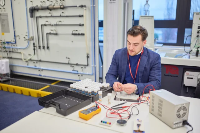Man working on an electronic device in a laboratory setting.