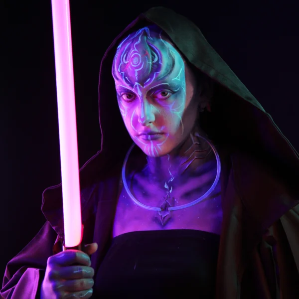 A woman in a hooded cloak holding a pink lightsaber, with neon blue and purple makeup and accessories, inspired by Star Wars.