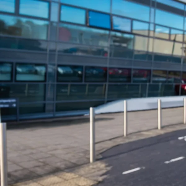 Modern building with large windows and a paved sidewalk, a road with bike lane markings in the foreground.