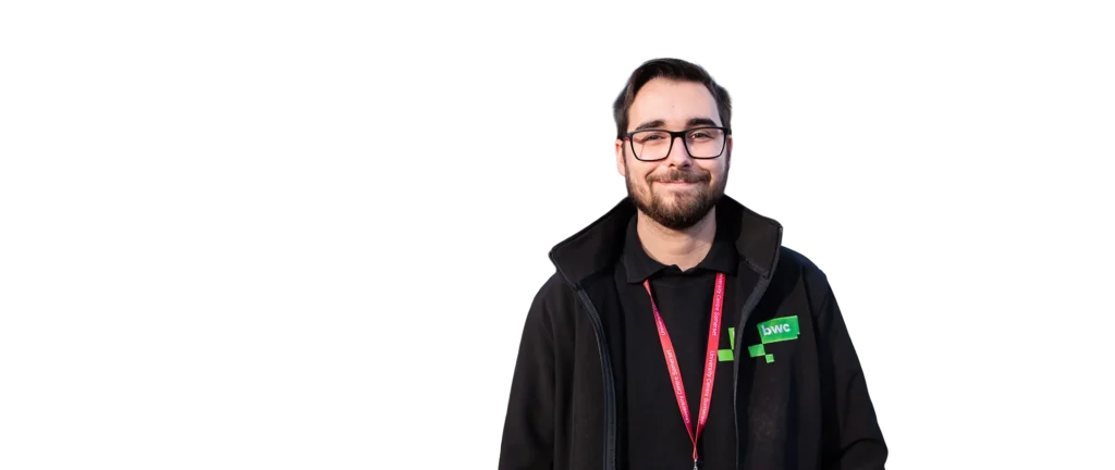 Man with short hair and glasses wearing a black hoodie and red lanyard.
