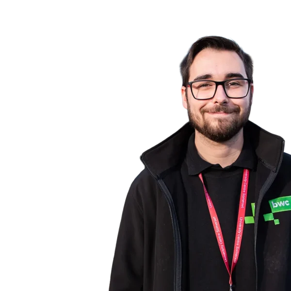 Man with short hair and glasses wearing a black hoodie and red lanyard.