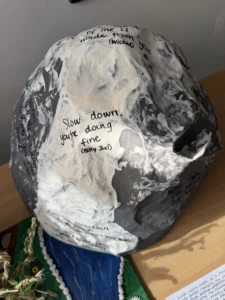 A painted stone with a motivational phrase on it.