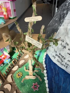 A creative display with a tree and signs, surrounded by various objects.