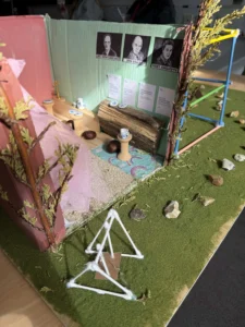 a model of a house with a green wall and a tree