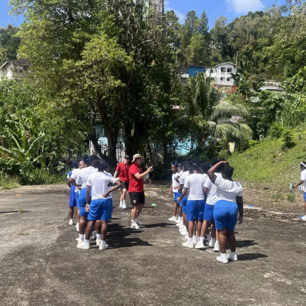 UCS sport students coaching school children in a playground in St Lucia