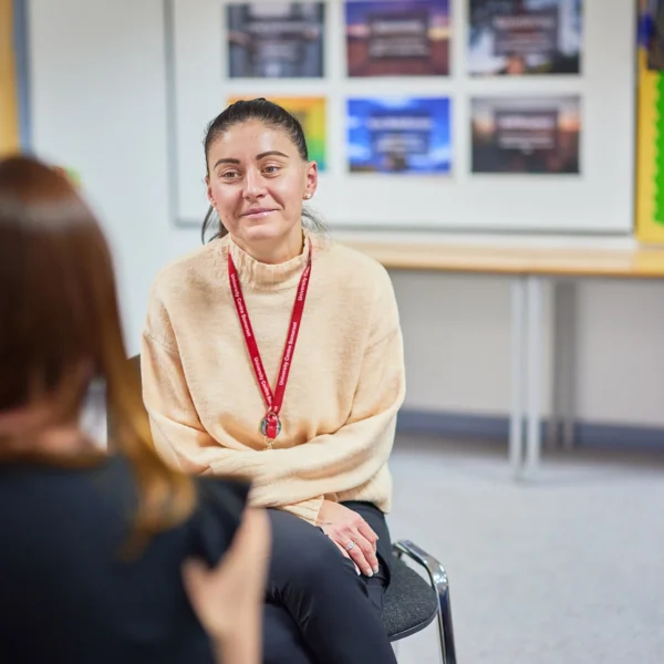 Woman sitting and talking to another woman