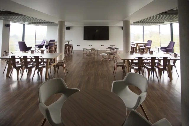 A large room with multiple tables and chairs.