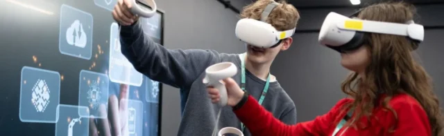 Two students wearing VR headsets interacting with a virtual interface.