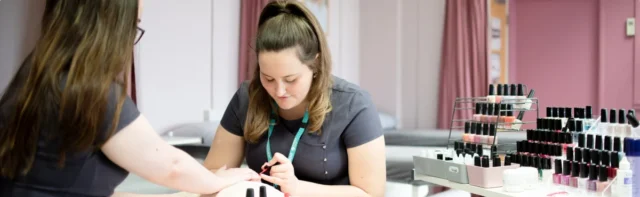 a woman getting her nails done by a technician