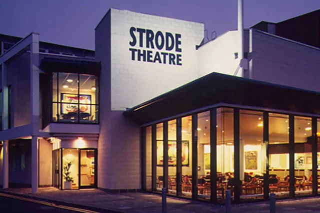 The Strode Theatre building exterior at dusk.