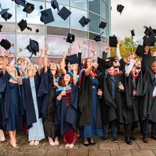 A group of graduates throwing their caps in the air, celebrating their achievement.