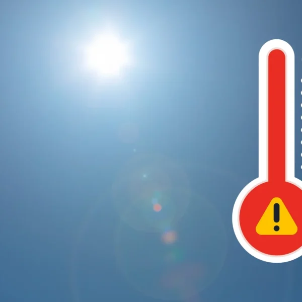 Thermometer icon with warning sign on a sunny background