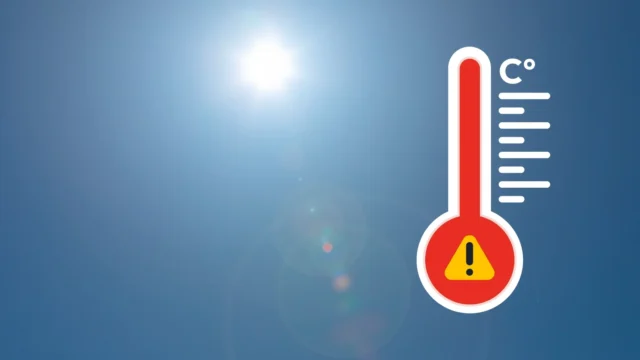 Thermometer icon with warning sign on a sunny background