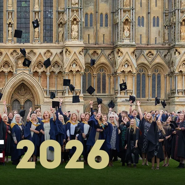 University Centre Somerset graduates in academic regalia standing in front of a historic building