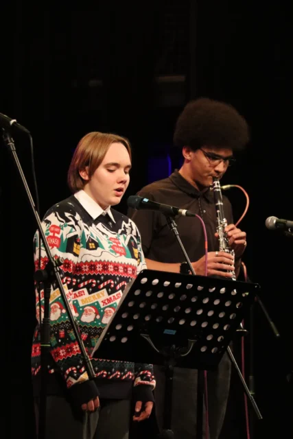 a man playing a violin and a woman singing into a microphone