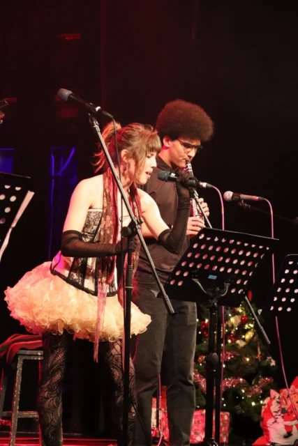 Elton John performing on stage with microphone
