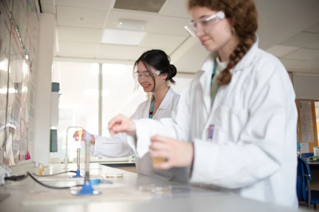 Two female scientists in lab coats working in a laboratory.