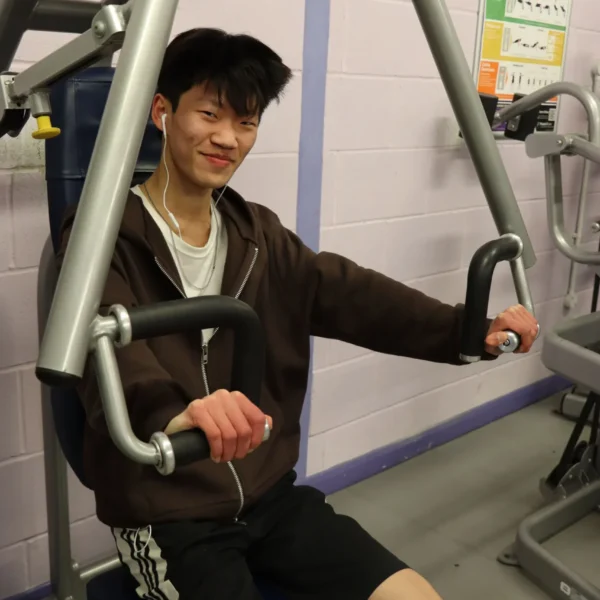 Young man working out on a machine at the gym.