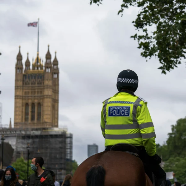 Police officers on horseback with the Elizabeth Tower in the background.