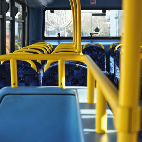 Interior of a bus with blue seats and yellow handrails