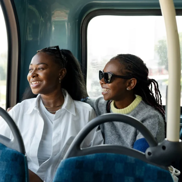 Two women sitting on a bus looking out the window.