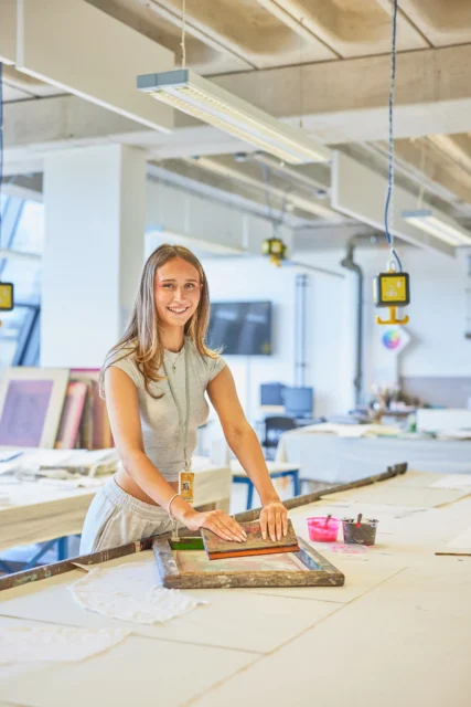 Woman in a modern office setting working with a large piece of paper.