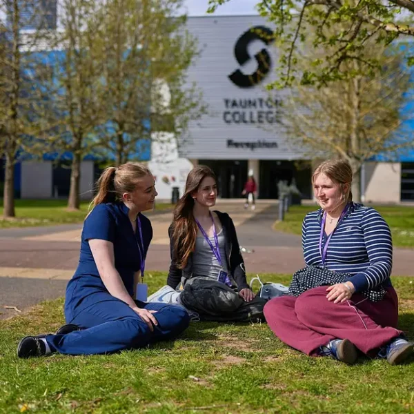 Students enjoy a sunny day on the grass at Taunton College Reception.